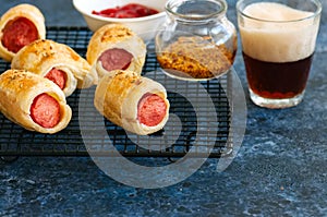 Pigs in a planket. Puff pastry rolls with sausages on a wire rack. Fast food or beer snack concept.