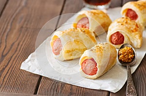 Pigs in a planket. Puff pastry rolls with sausages on a wooden b