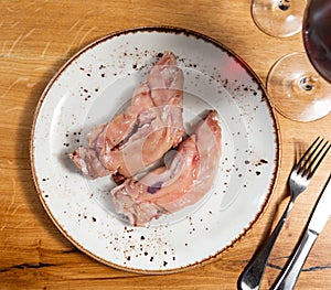 Pigs trotter served on white circular plate close up