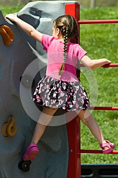 Pigtail Girl Climbing a Rock Wall