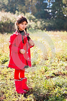Pigtailed girl in the red coat and red boots