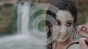 Pigtailed girl smiles as she looks back at her friend in a lake