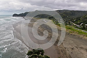 Piha black sand beach featuring cliffs and rock formations in New Zealand