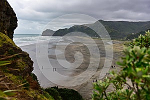 Piha black sand beach featuring cliffs and rock formations at Waitakere in New Zealand