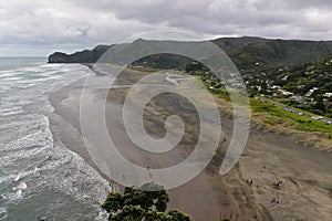 Piha black sand beach featuring cliffs and rock formations at Waitakere in New Zealand photo