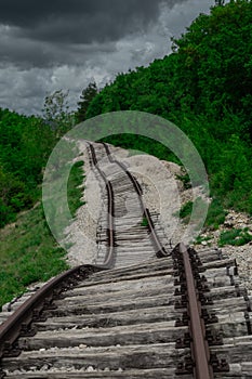 Pijana pruga or drunk railway in Istria, Croatia. A stretch of neglected railway track and bed, deformed rails, washed down by photo