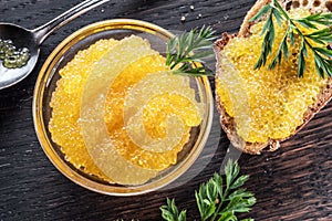 Pike caviar or roe in the bowl on wooden background photo