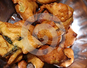 Pikora, pakoda, pakodi, fakkura, bhajiya, bhajji, bhaji or ponako, is a fried snack fritter on the plate. photo