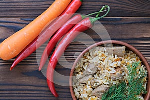 Pilaf with meat in a clay plate with herbs