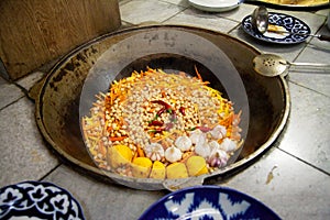 Pilaf with rice, meat, quince and chickpeas is cooked in a large cauldron in Bukhara in Uzbekistan