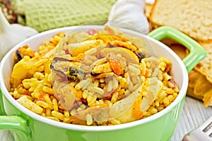 Pilaf with seafood and bread on board