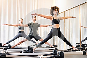 Pilates class of diverse people doing standing yoga poses photo
