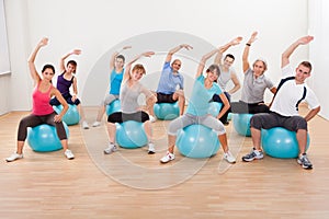 Pilates class exercising in a gym