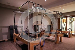 Pilates class gym equipment reformers beds.