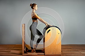 Pilates, fitness, sport, training and people concept - woman doing exercises on a small barrel. Correction of impellent