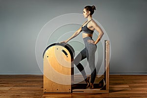 Pilates, fitness, sport, training and people concept - woman doing exercises on a small barrel. Correction of impellent