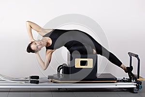 pilates machine, woman in sportswear exercising in the gym