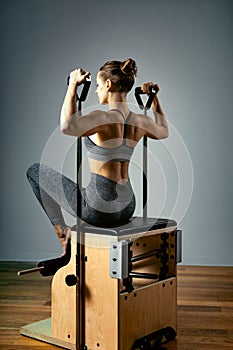 Pilates reformer chair woman fitness yoga gym exercise. Correction of musculoskeletal system, beautiful body. Correct