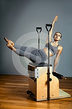 Pilates reformer chair woman fitness yoga gym exercise. Correction of musculoskeletal system, beautiful body. Correct