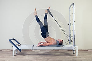 Pilates reformer workout exercises man at gym