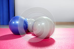 Pilates toning balls over red yoga mat