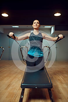 Pilates training on exercise machine in gym