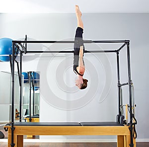 Pilates woman in cadillac acrobatic upside down