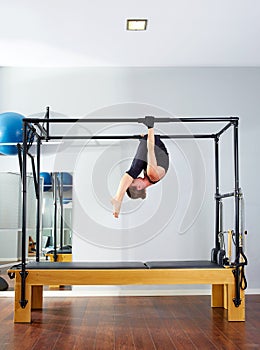 Pilates woman in cadillac acrobatic upside down