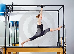 Pilates woman in cadillac legs split reformer