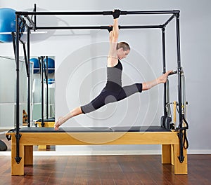Pilates woman in cadillac legs split reformer photo
