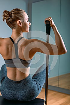 Pilates woman in a Cadillac reformer doing stretching exercises in the gym. Fitness concept, special fitness equipment