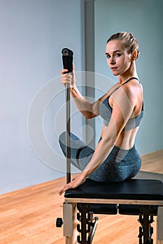 Pilates woman in a Cadillac reformer doing stretching exercises in the gym. Fitness concept, special fitness equipment