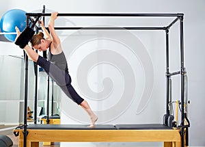 Pilates woman in cadillac split legs stretch exercise