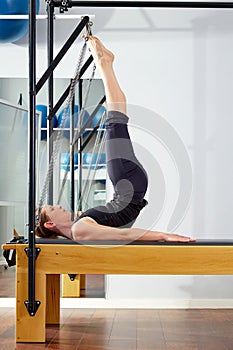 Pilates woman in reformer tower exercise at gym