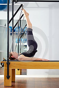Pilates woman in reformer tower exercise at gym photo