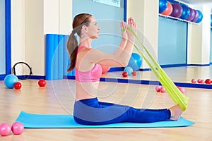 Pilates woman rowing rubber band exercise