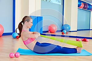 Pilates woman rowing rubber band exercise