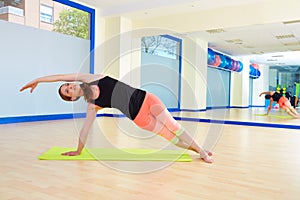 Pilates woman side bend exercise workout at gym