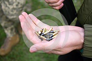 A pile of 22 LR bullets with a round head in the guy& x27;s hand.