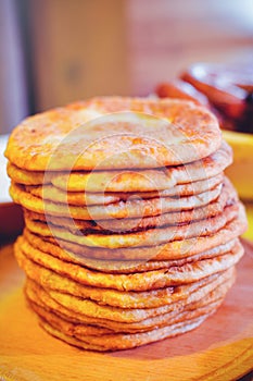 Pile of air pancakes on a wooden dinette, a traditional food family. pancakes of golden color