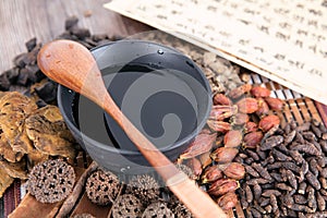 A pile of all kinds of traditional Chinese medicine and prescriptions and a bowl of decocted decoction