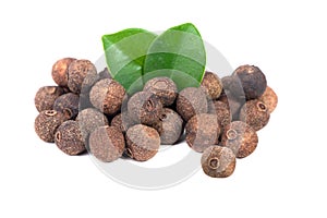 Pile of allspice isolated on white background. Jamaica pepper, allspice peppercorns or myrtle pepper with green leaves.