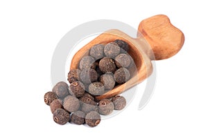 Pile of allspice isolated on white background in a spoon. Jamaica pepper, allspice peppercorns or myrtle pepper.