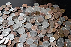 A pile of American cents on an old black wooden surface close-up. Money background