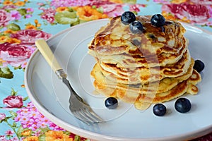 A pile of american pancakes with maple syrup