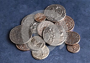 Pile of Ancient Roman Coin Replicas on a Blue Background