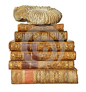 Pile of antique books with a leather cover and golden ornaments on white