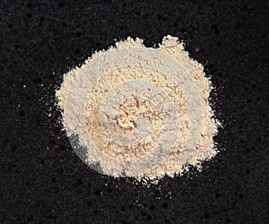 Pile of apple pectin powder close up on black