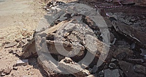 Pile of asphalt rubble on roadside. Road repair works in city