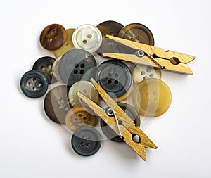 Pile of Assorted Colorful Buttons and Wooden Clothes Pins Isolated on White